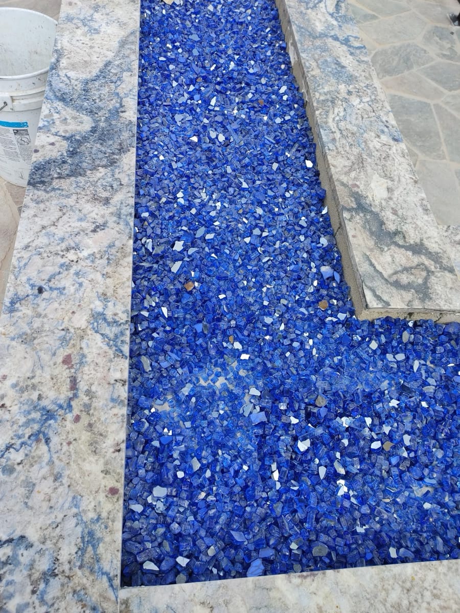 Outdoor fire pit filled with cobalt-blue fire glass.