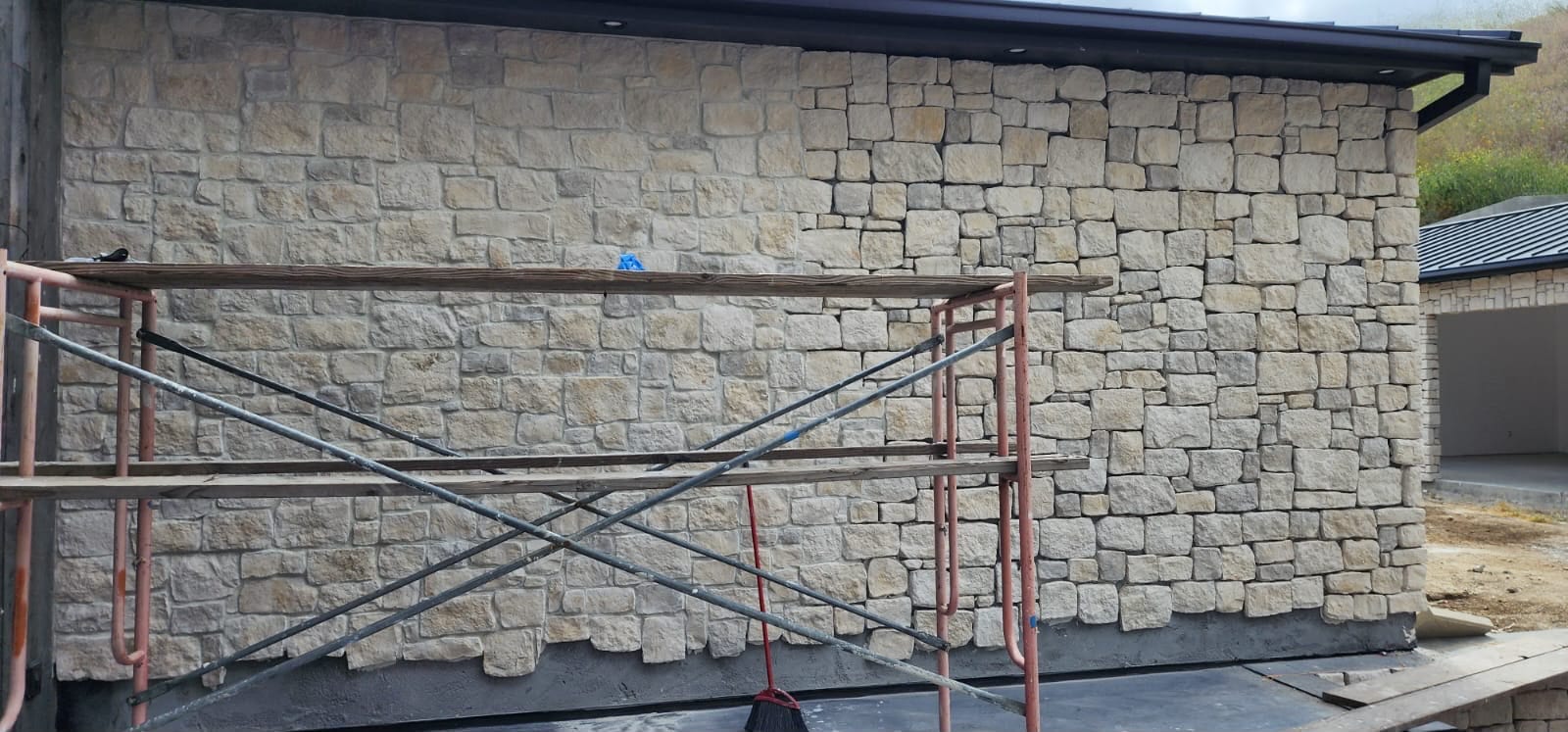 Exterior masonry detail on a finished VIP project — stone veneer applied over fully prepared wall assembly.