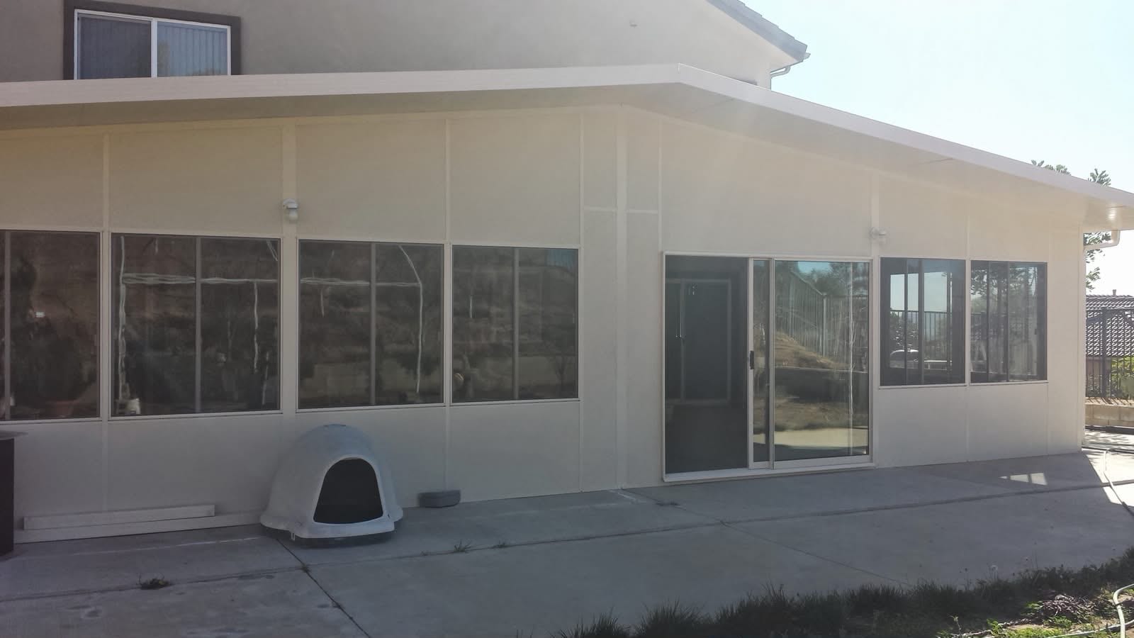 Completed patio enclosure attached to the home — full-height windows and matching roofline.