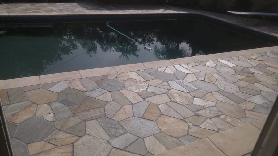 In-ground pool with dark plaster and flagstone coping and deck.